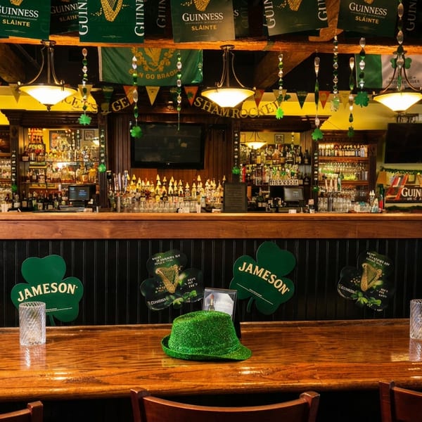 A festive Irish pub bar decorated with Guinness banners, Jameson shamrocks, and a green fedora.
